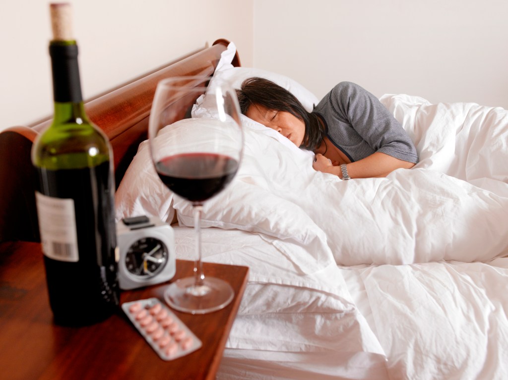 Pictured is a glass of wine while someone sleeps off a hangover