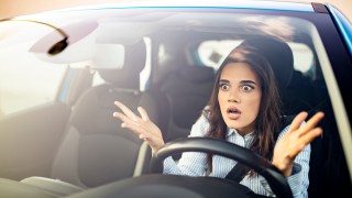 Frustrated woman stuck in traffic.