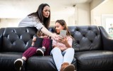 Pictured are two children on their phones, to illustrate social media use, with a parents.