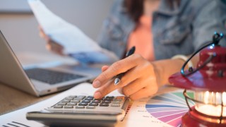 Pictured is someone working out their budget