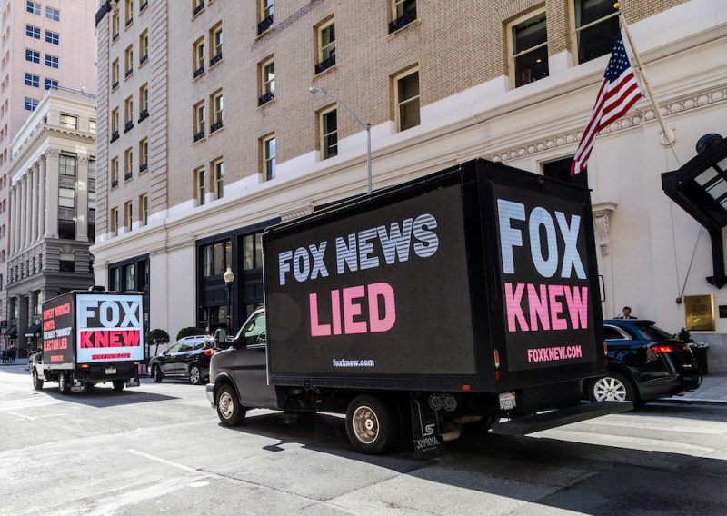 Truck billboards drive in front of the Palace Hotel calling out Fox News' election denial scheme as Fox CEO Lachlan Murdoch attends an event on March 08, 2023 in San Francisco, California