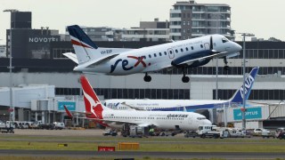 Pictured is a Qantas plane and Rex plane at Sydney Airport